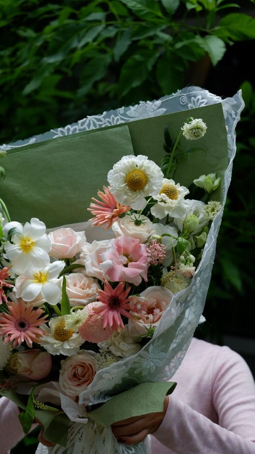 Free Capture of a beautiful bouquet of mixed flowers held outdoors, perfect for weddings or celebrations. Stock Photo