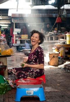 一位老妇人坐在熙熙攘攘的越南市场里，脸上洋溢着温暖的笑容。 - 相关推荐