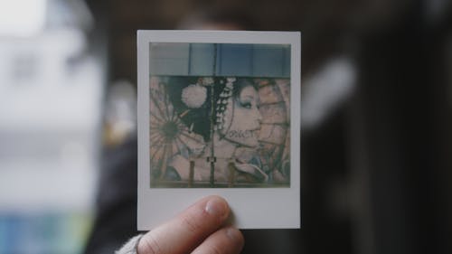 Person Holding White Polaroid Photo