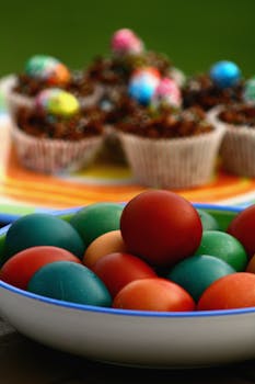 Colorful Easter eggs and decorated cupcakes in a festive setting.