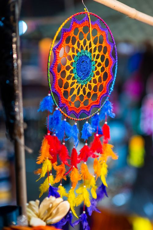 Free Vibrant handmade dreamcatcher with colorful feathers hanging indoors, adding a bohemian touch. Stock Photo