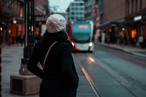Person in Black Jacket Standing on Sidewalk