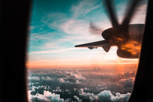 Free Airplane Flying over Clouds during Sunset Stock Photo