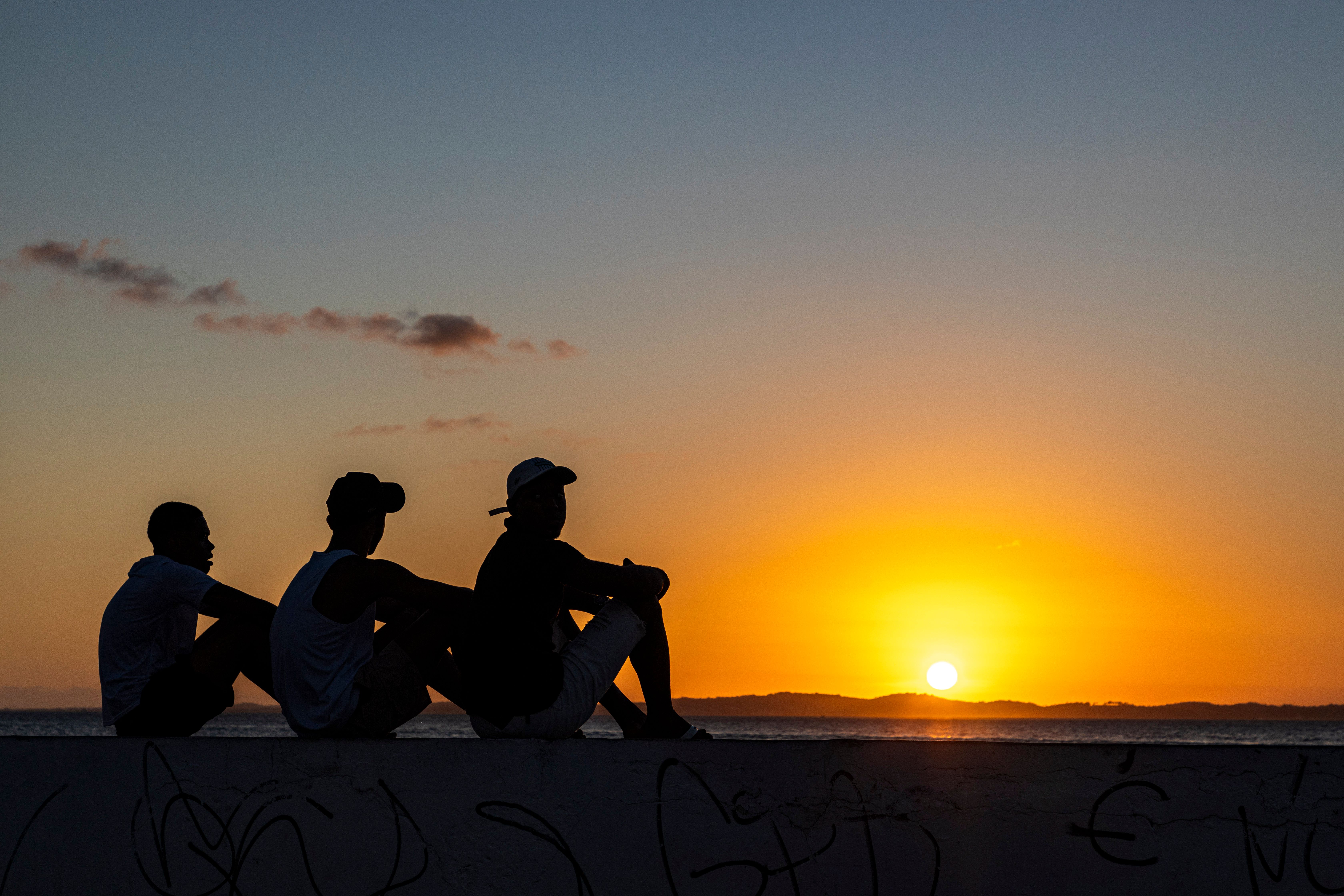 Silhouette of Three People at Sunset Beach · Free Stock Photo
