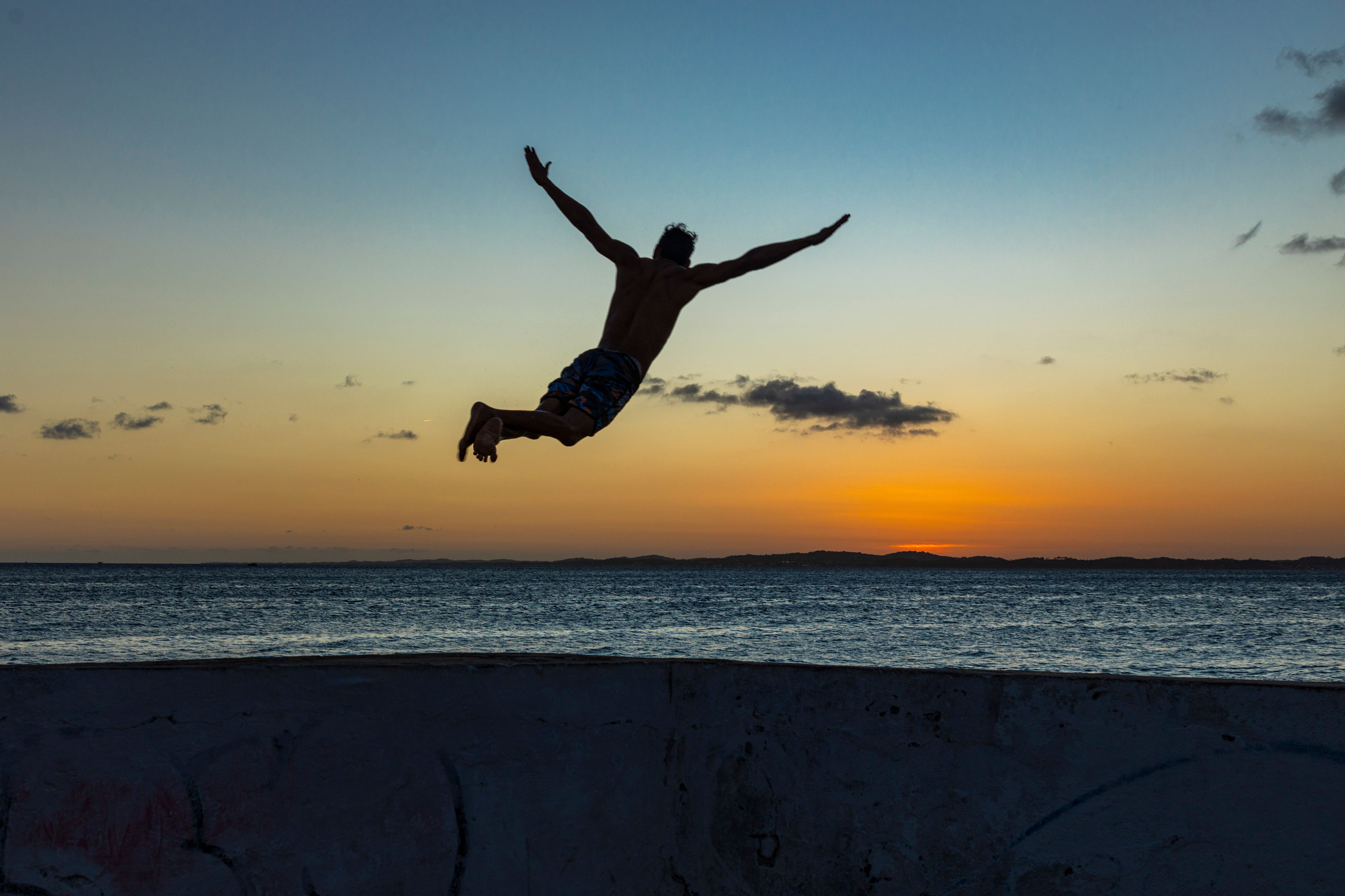 Man Jumping at Sunset Ocean Silhouette · Free Stock Photo