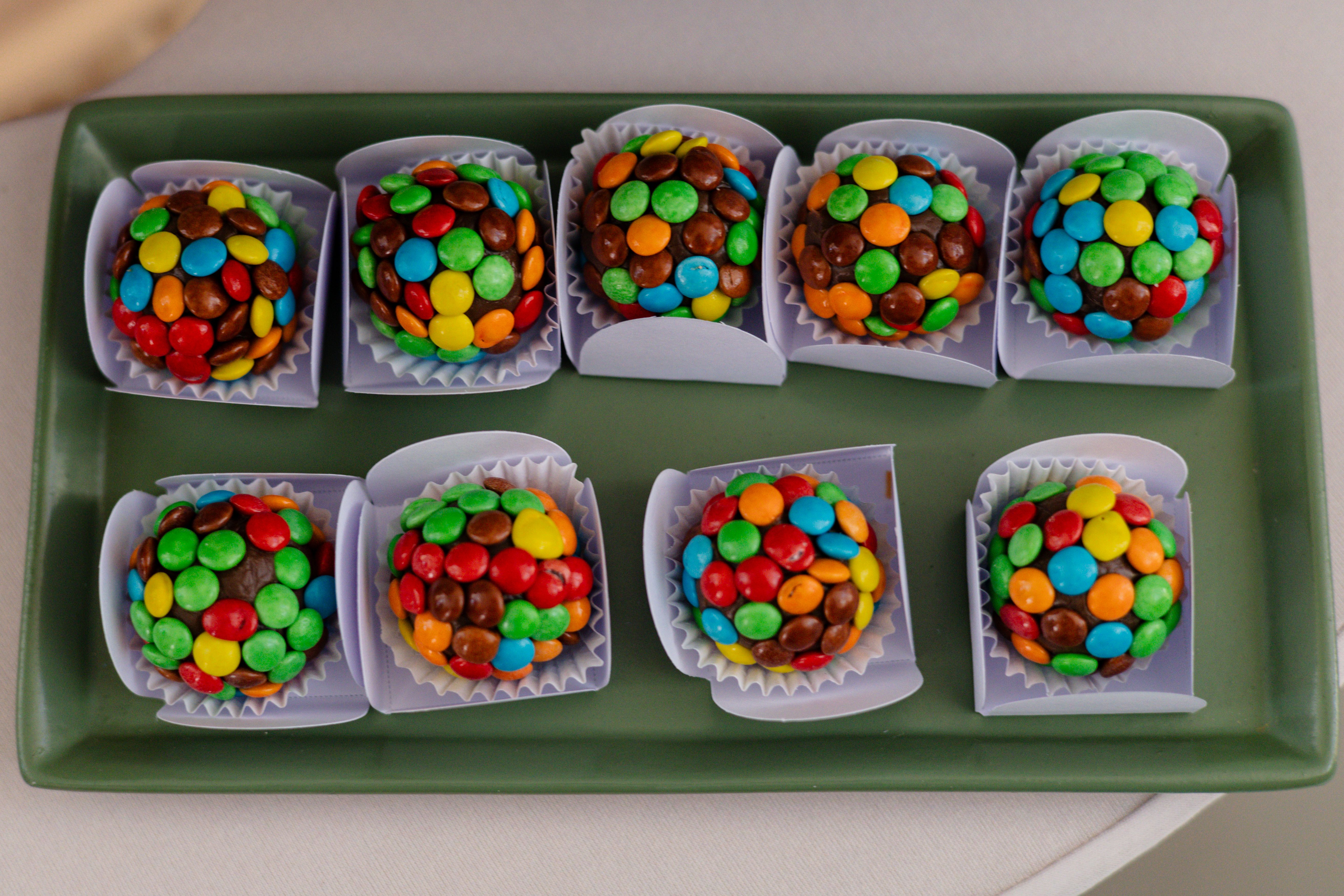 Trufas De Chocolate De Colores En Bandeja Verde · Foto de stock gratuita