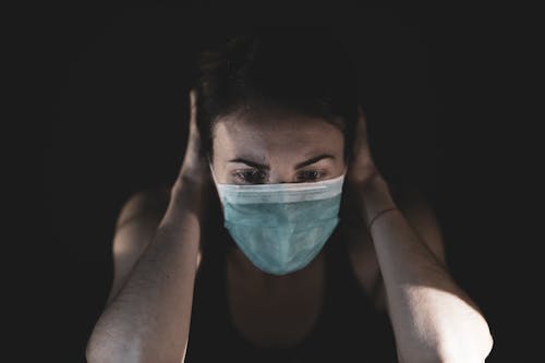 Free Woman Covering Her Face With Surgical Mask Stock Photo