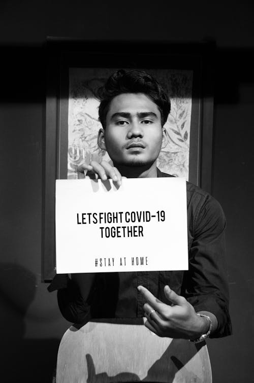 Grayscale Photo of Man Holding a Card