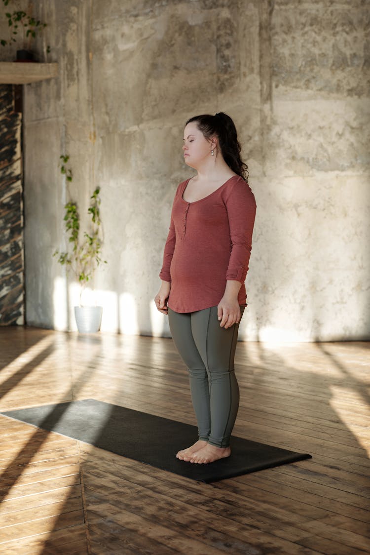 Woman In Long Sleeves And Leggings Standing On A Yoga Mat