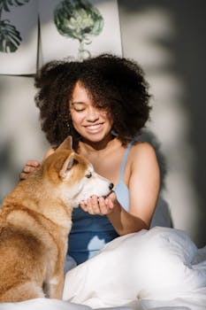 一位快乐的卷发女人，带着她的柴犬，住在舒适的卧室里