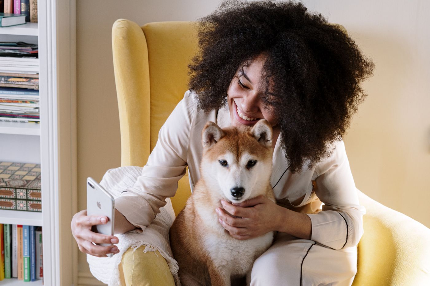 Pet owner using a smartphone while relaxing at home with a dog