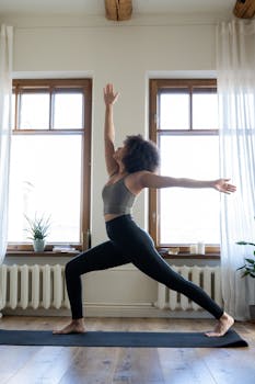 Woman practicing yoga in a well-lit modern home setting, promoting wellness and tranquility.