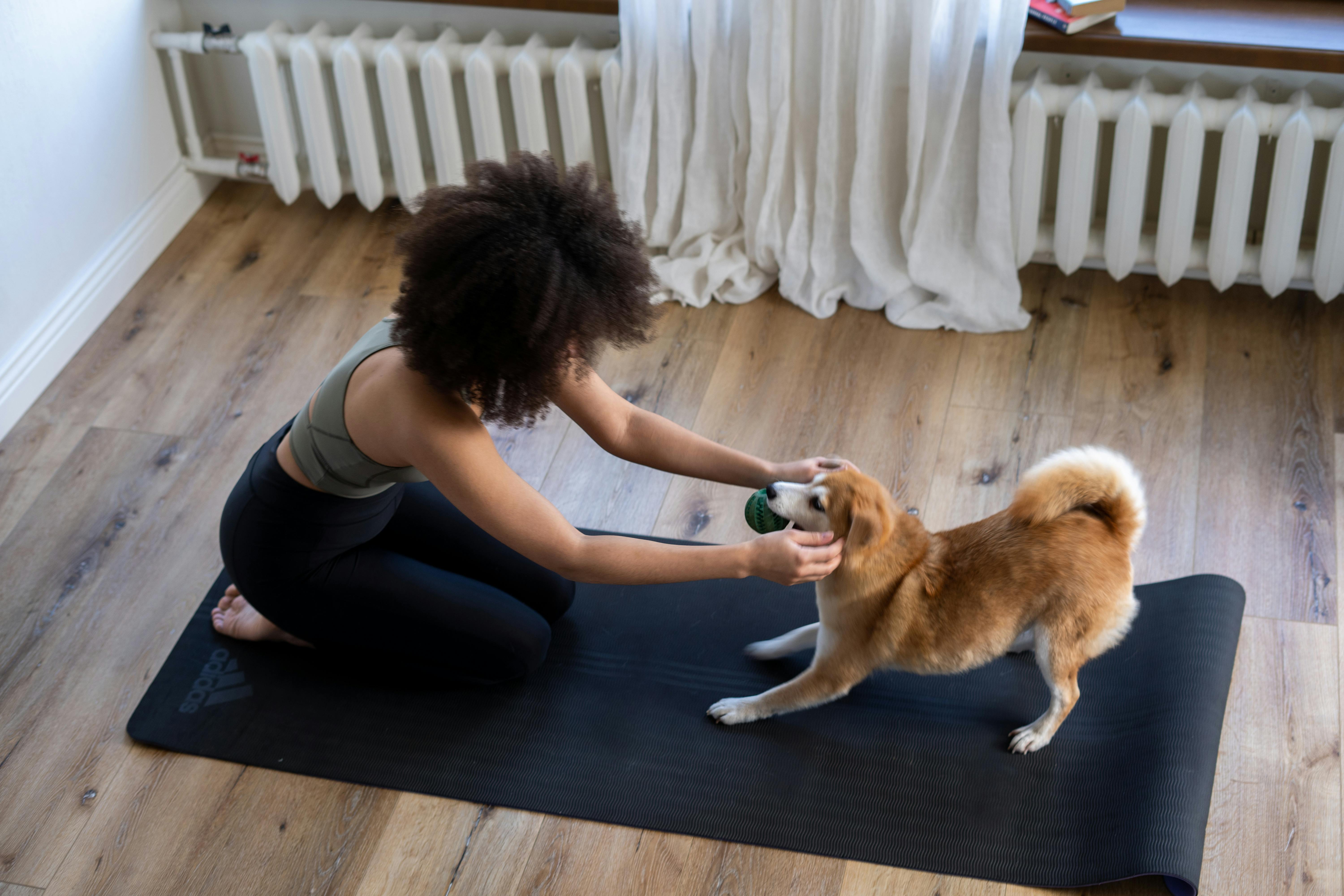 woman with dog on yoga mat