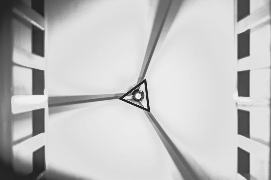 Abstract view of a geometric ceiling in black and white, emphasizing symmetry and modern design.
