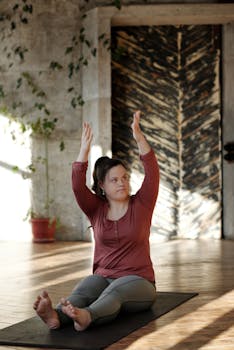 A young woman with Down syndrome performs a yoga pose indoors, promoting wellness and flexibility.