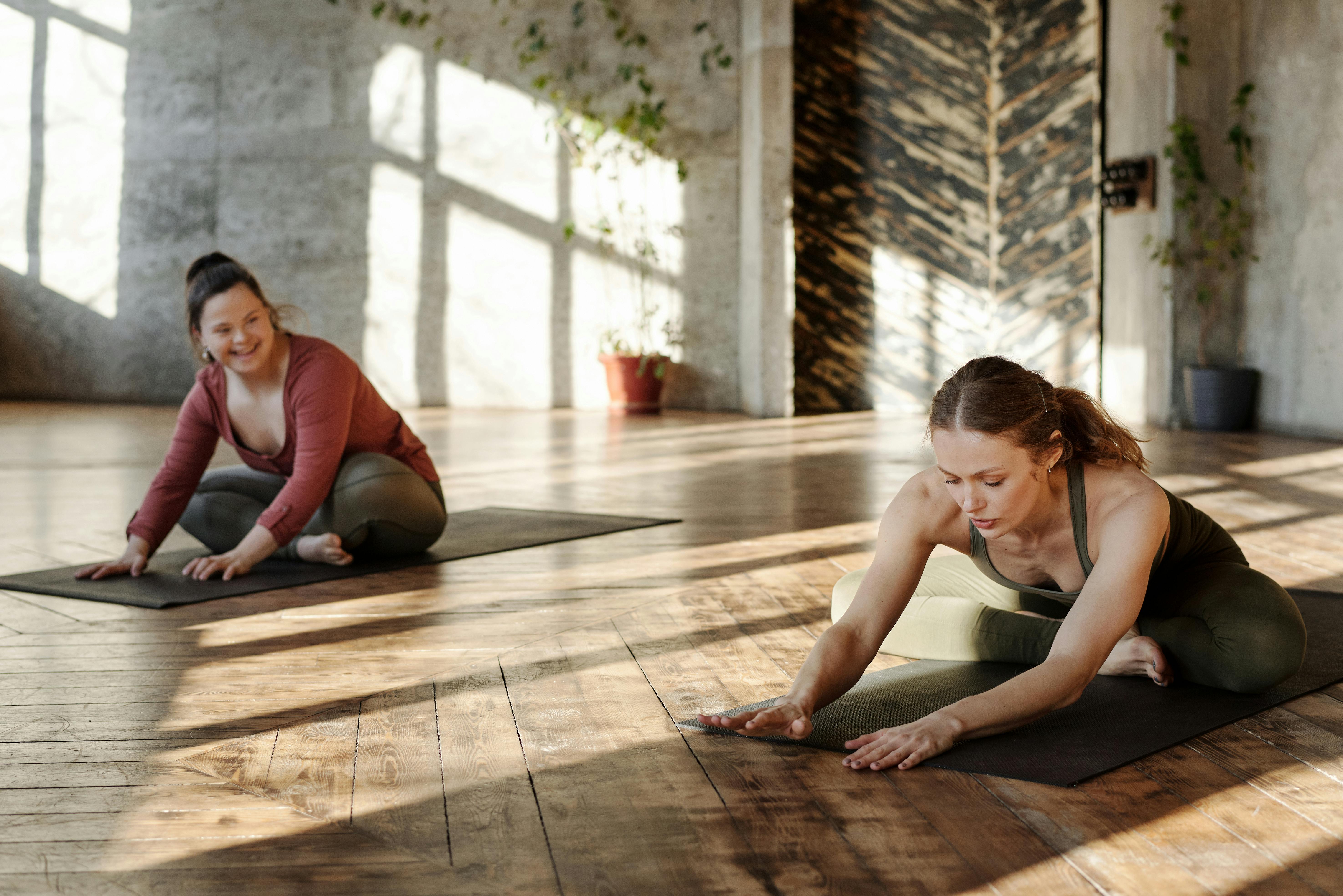 Two girls doing yoga stretching in fitness class Stock Photo