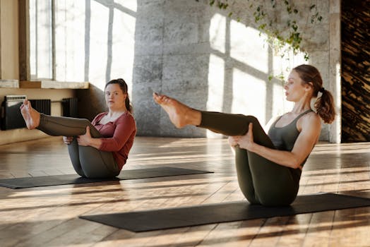 Two women practicing yoga poses together in a bright studio, promoting inclusivity and fitness.