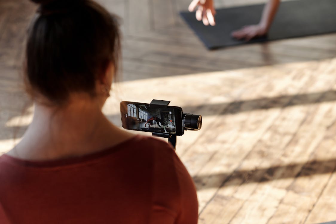 A Girl Taking Video Of A Woman Exercising