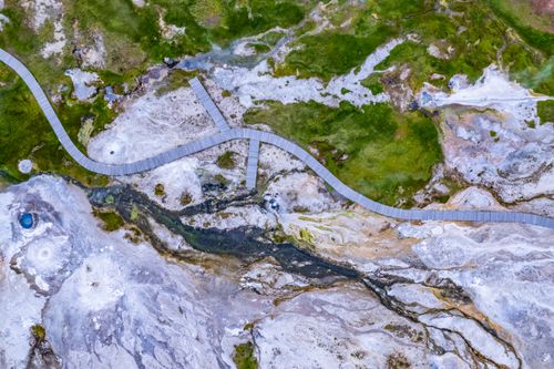Free Aerial view of geothermal landscape in Húnabyggð, Iceland, featuring winding wooden walkways. Stock Photo