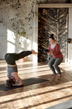 两名女性在室内练习瑜伽并拍摄，以促进健身和健康