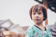 Girl in Teal and White Floral Shirt Looking Curious