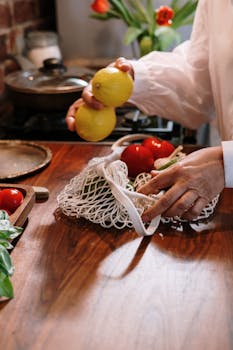 Hands arranging fresh vegetables and lemons on a kitchen table, highlighting home cooking.