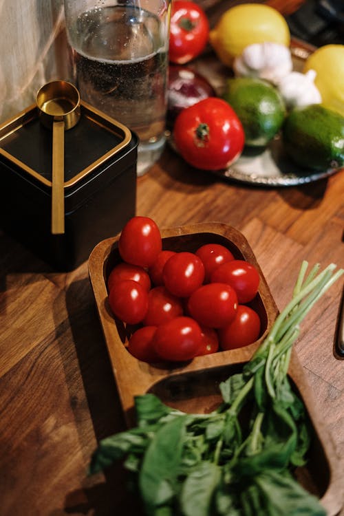 Photo Of Red Tomatoes And Basil Leaves On Wooden Bowl