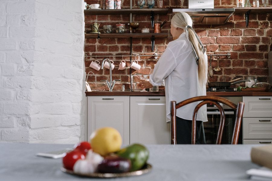 Coach in a kitchen surrounded by fresh whole foods