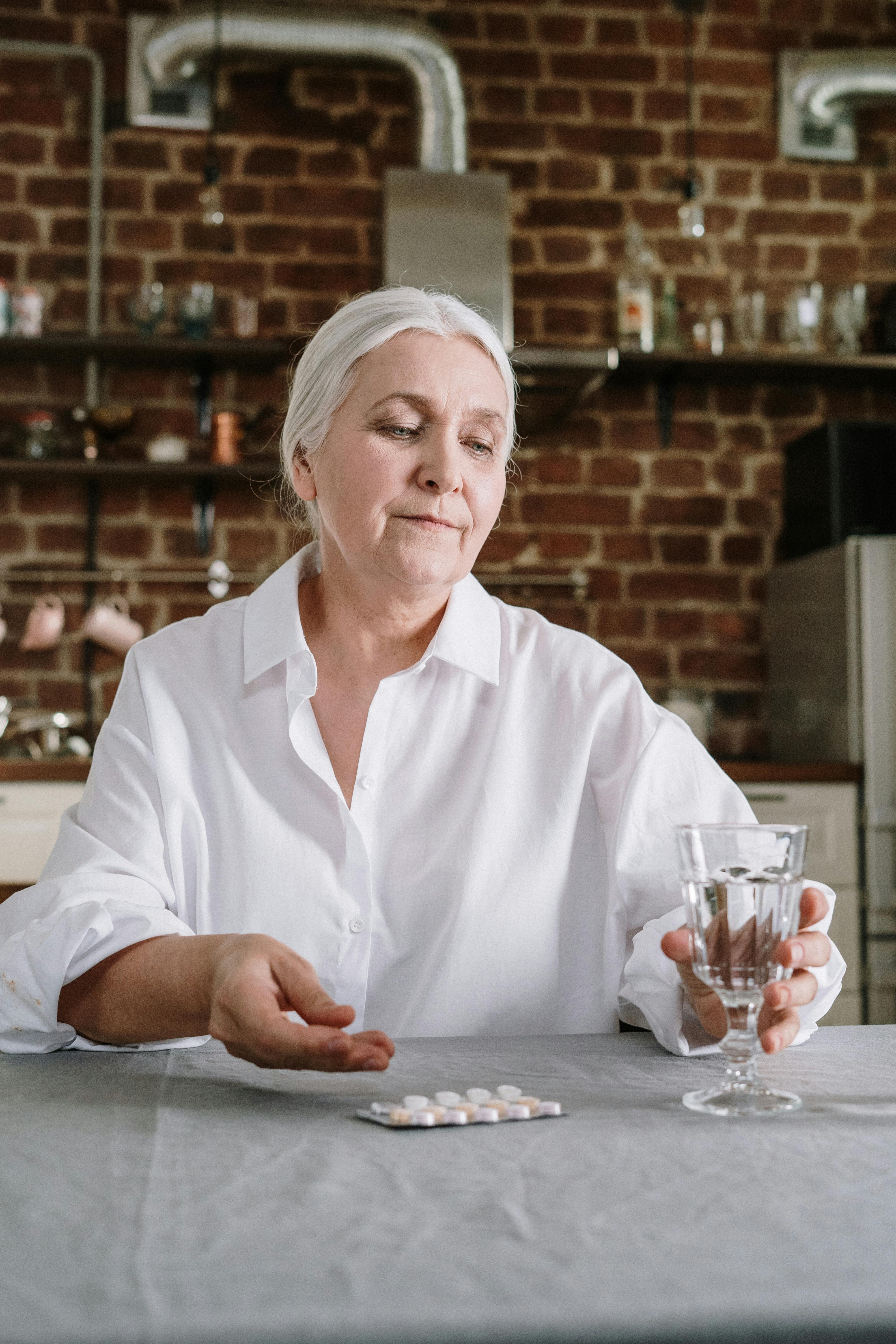 an elderly woman taking her medicines