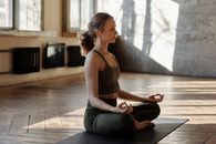 一名女子在室内冥想，以平静的瑜伽姿势享受健康和放松的感觉