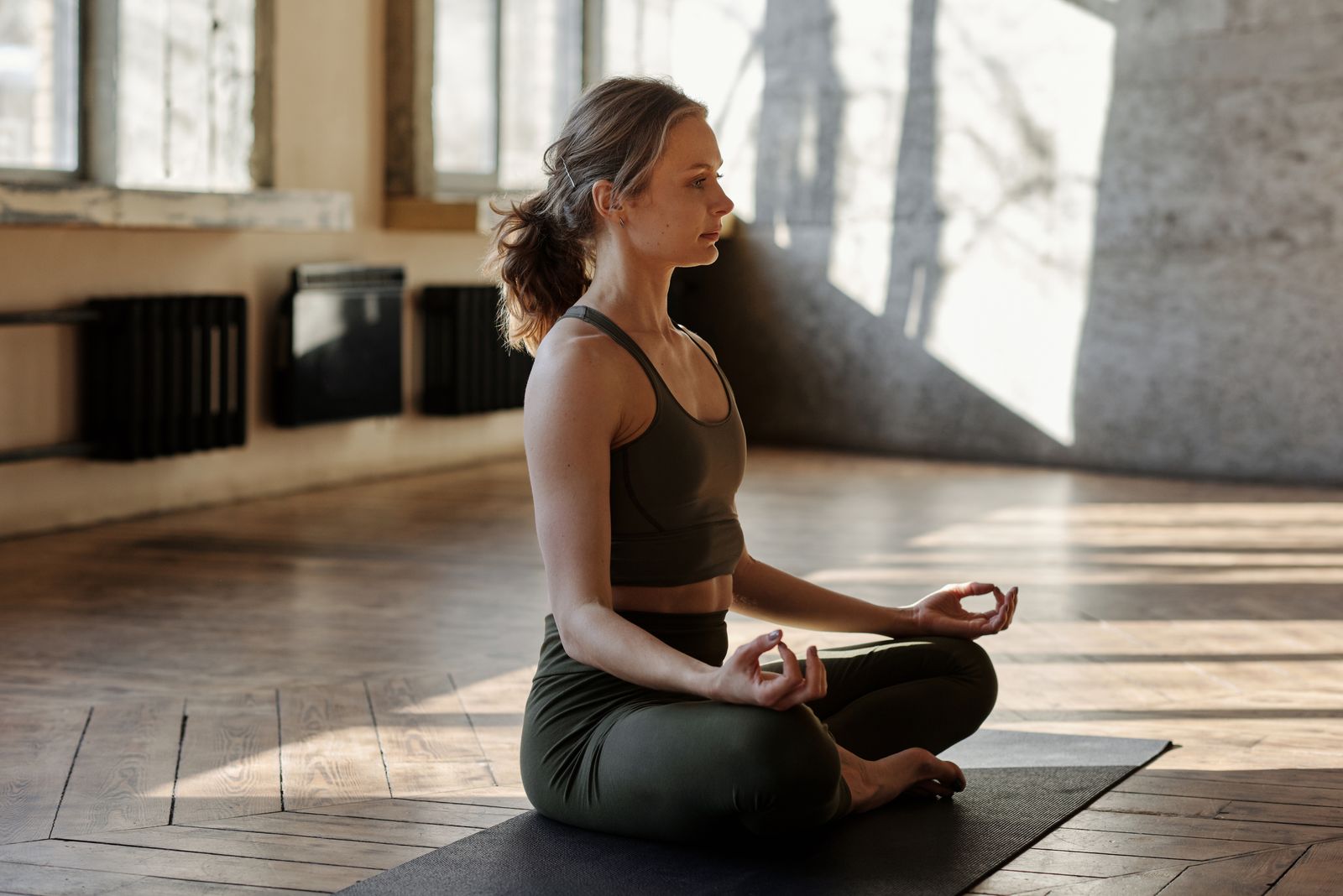 Woman practicing a calm seated yoga pose indoors to support focus and memory