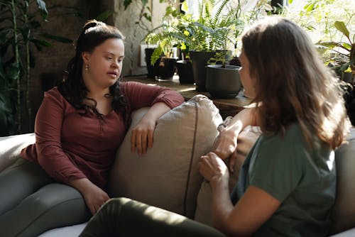 Free Two Women Sitting on a Couch Chatting Stock Photo