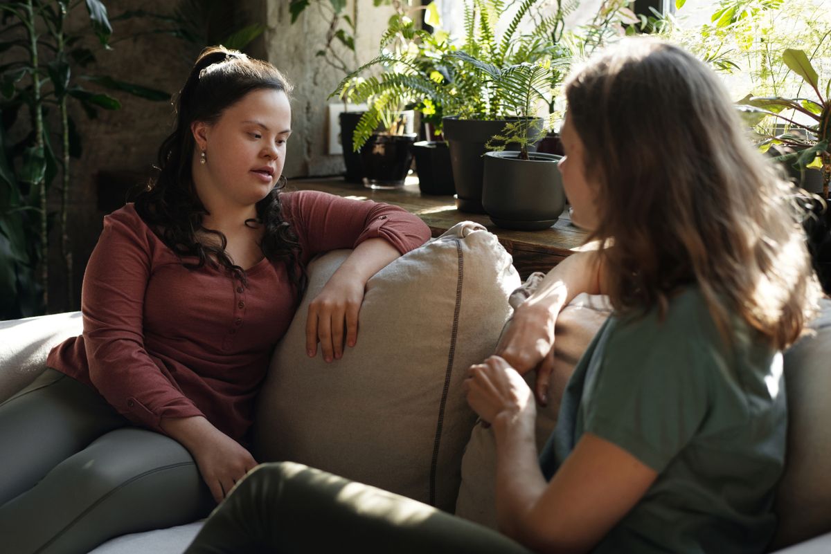 Twee mensen in een rustig gesprek op de bank, in een vertrouwde omgeving