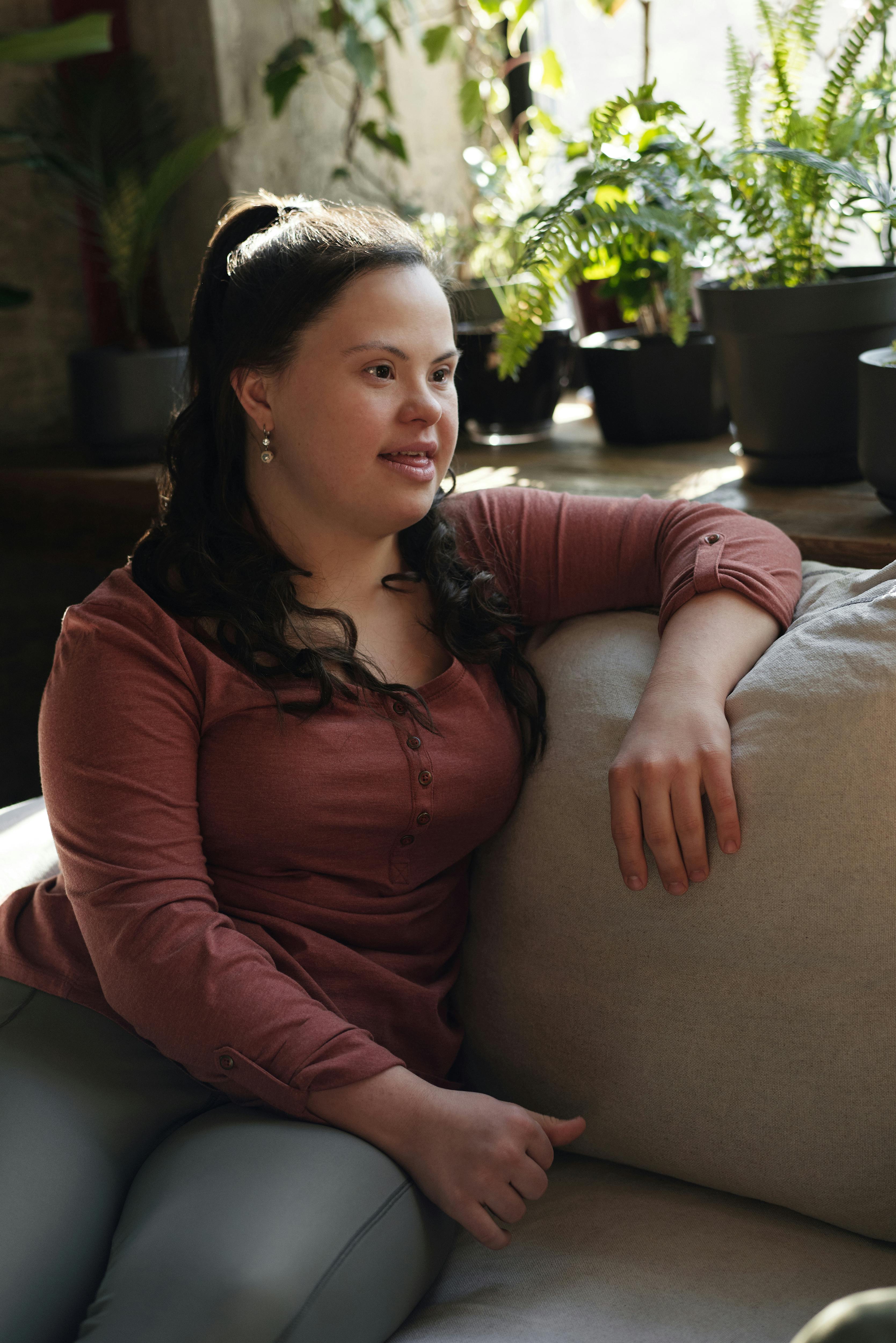 woman sitting on the couch near green plants