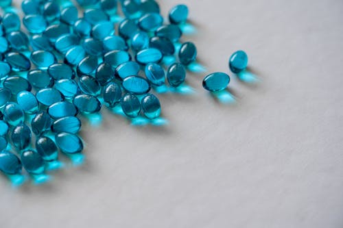 Free Blue Gel Capsules on White Textile Stock Photo
