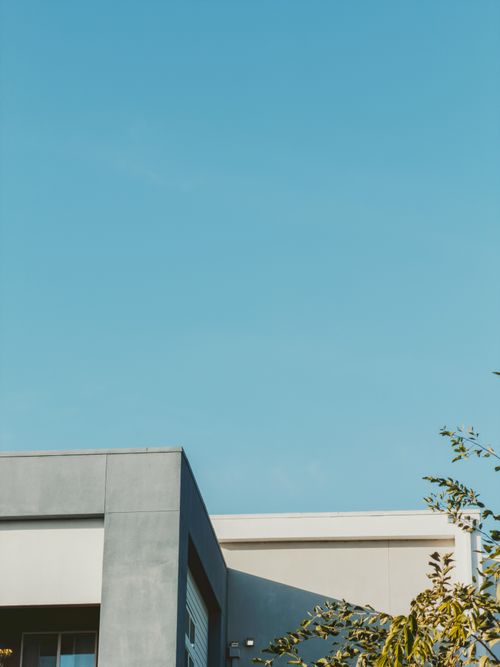 Free Minimalist photo of a modern gray building against a vivid blue sky. Stock Photo