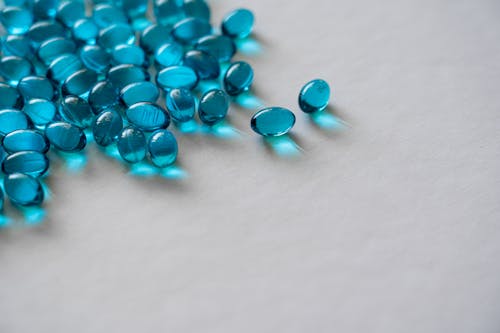 Free Blue Gel Capsules On White Surface Stock Photo