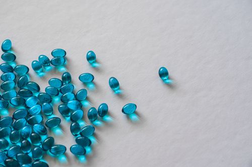 Free High angle view of scattered blue gel capsules on a flat white surface. Stock Photo
