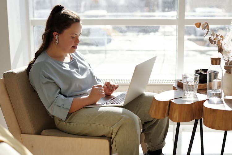  Girl Sitting On A Couch Using A Laptop