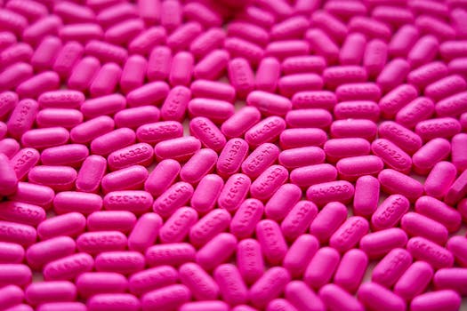 Bright pink antihistamine pills scattered for allergy treatment visualization.
