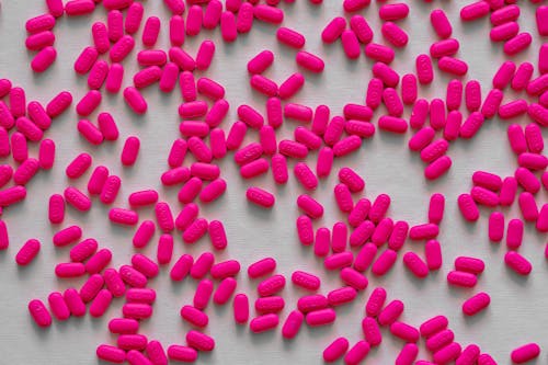 Scattered Pink Tablets On Gray Surface