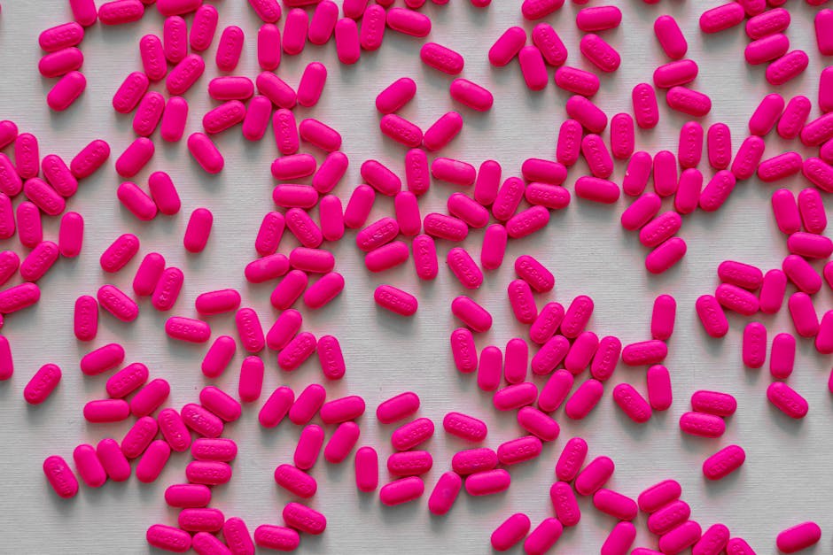 Bright pink tablets scattered randomly, illustrating medicine and healthcare concepts.