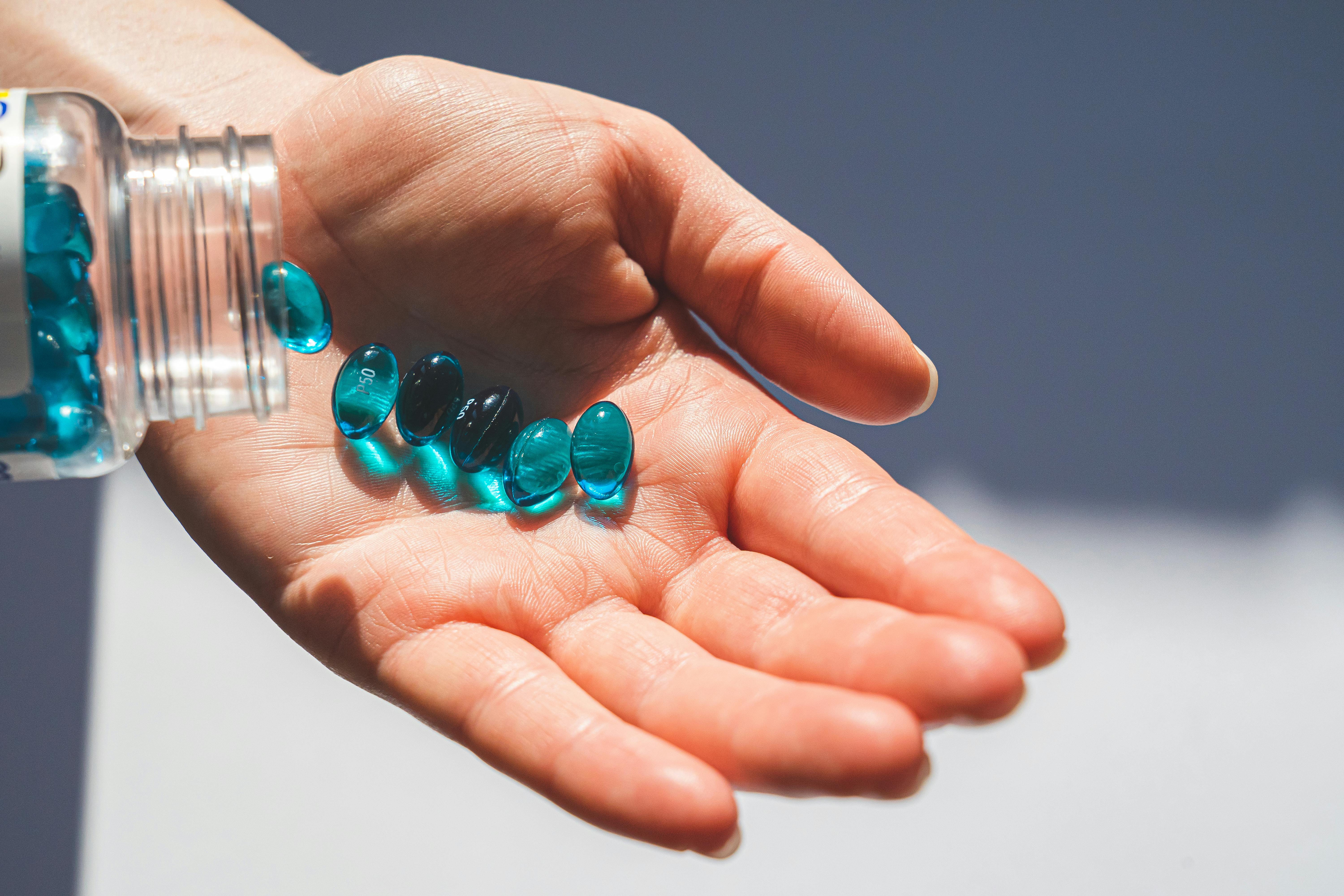 person holding blue pills