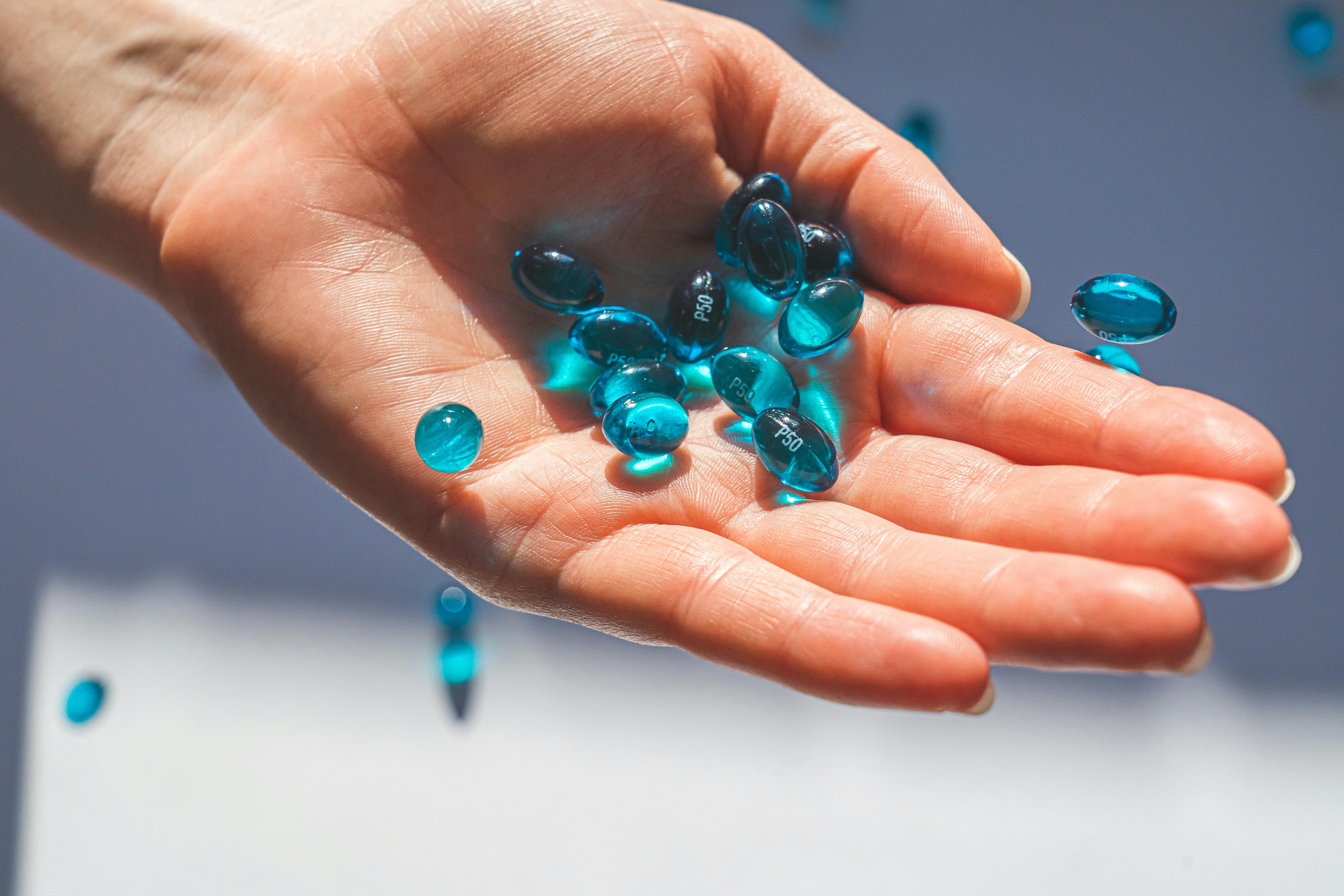 person holding blue pills