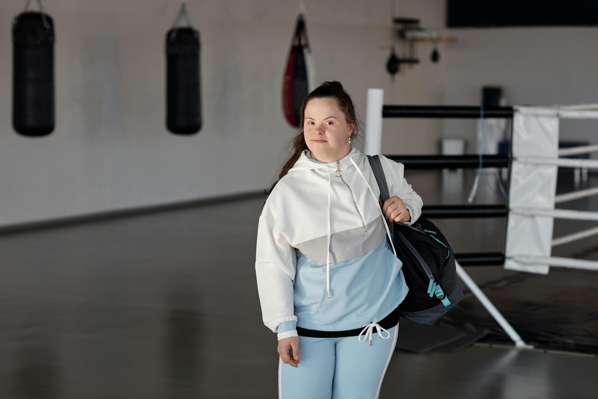 Woman Carrying a Black Bag in a Boxing Gym