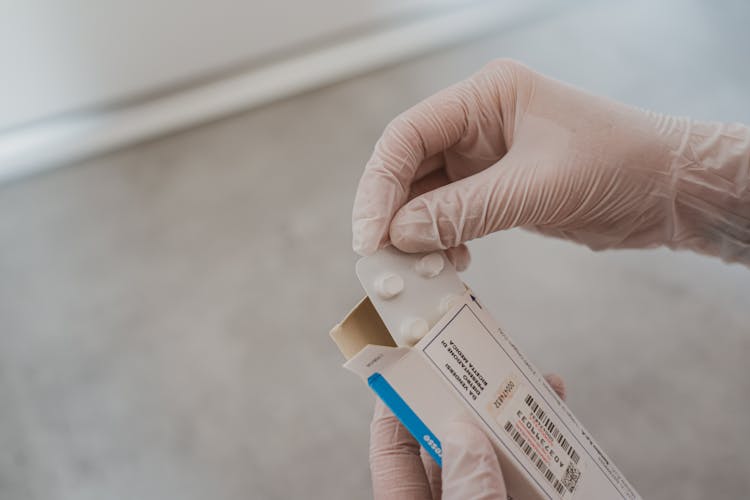 Person Holding White And Blue Box