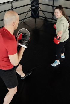 Man Training a Woman in a Boxing Ring