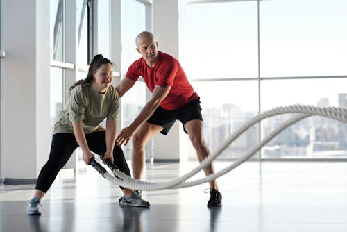 Free A Woman Holding Ropes Beside a Trainer Stock Photo