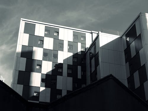 Bâtiment Blanc Et Noir Sous Ciel Nuageux