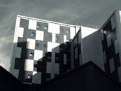 现代建筑低矮的视角下，玻璃和钢铁立面映照着城市的天空